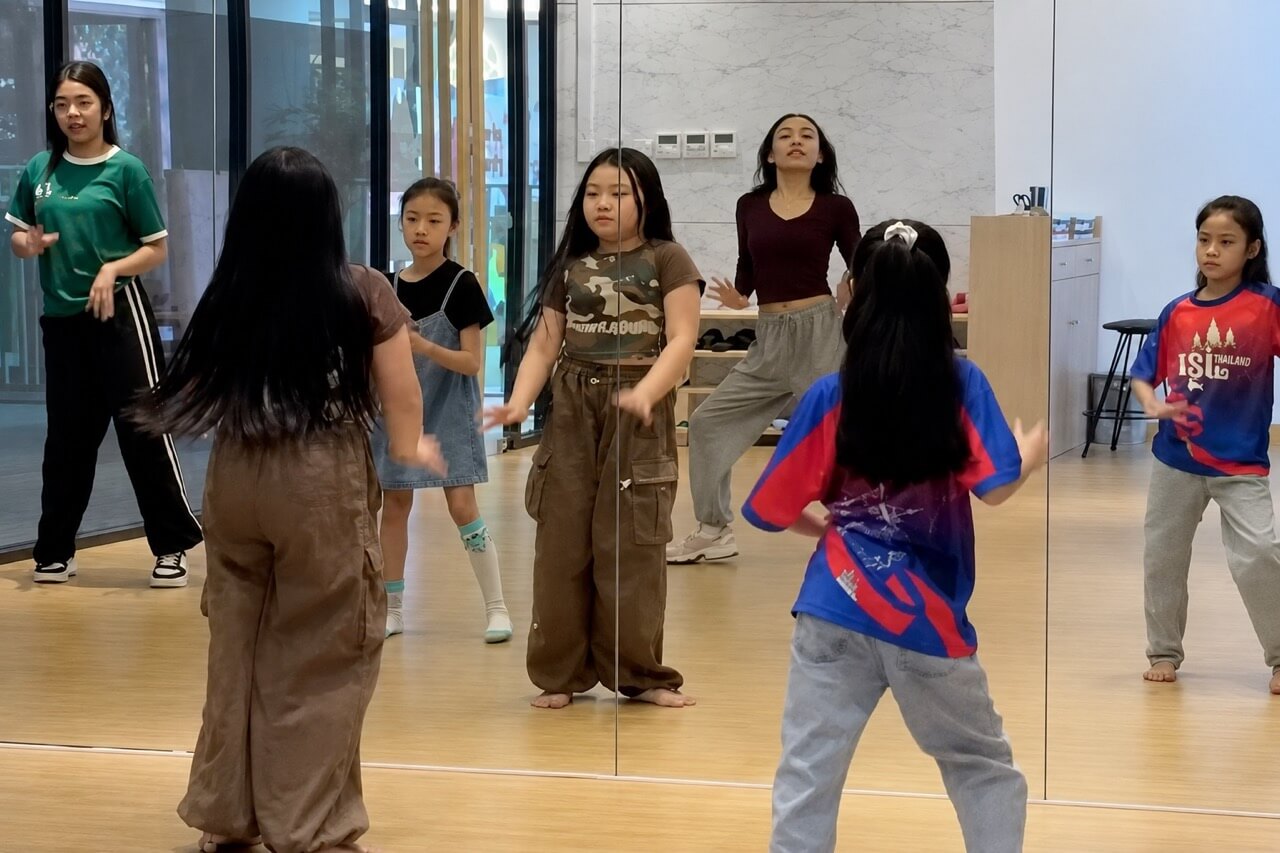 少人数制のダンスクラスで、インストラクターが生徒一人ひとりを丁寧に指導している様子