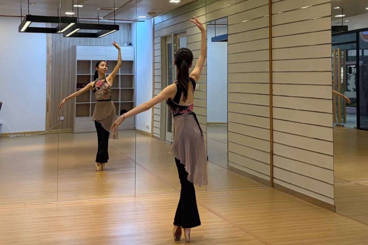 鏡のあるスタジオで、大人の女性がBeauty Balletのレッスンを受けている様子