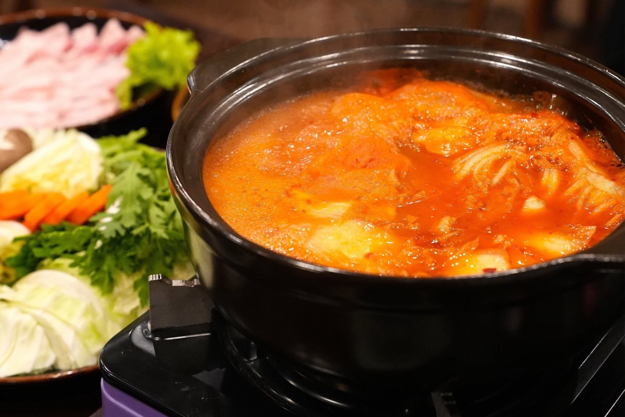 キムチスープと豚肉、野菜、きのこのイメージ