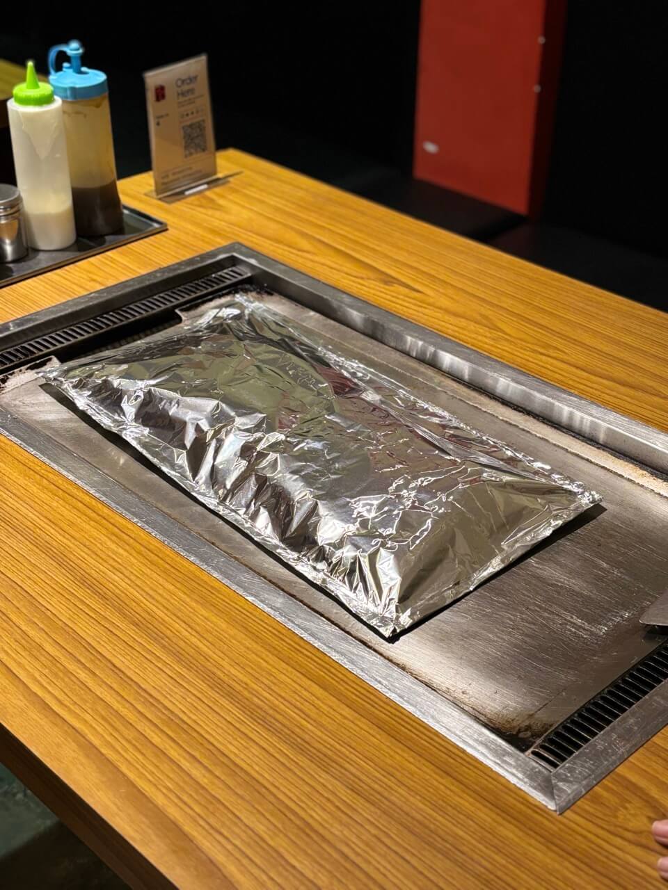 鉄板の上でアルミホイルに包まれて焼かれるドリアン